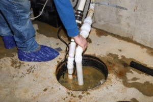 an image of a man cleaning a sump pump in the basement